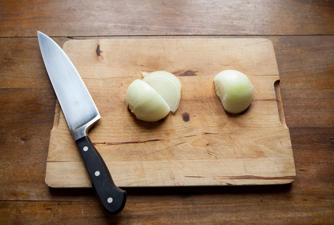 Lo chef taglia la cipolla con un coltello su un tagliere da cucina per la  conservazione in barattolo deliziose verdure inscatolate dalle mani del  cuoco